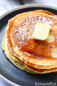 pancakes with butter and syrup on a plate, ready to be eaten or served for breakfast