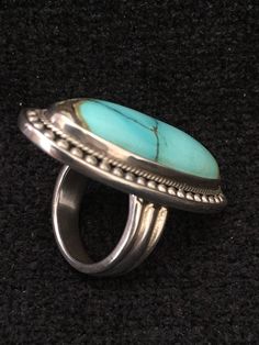 "Ring ~ Artist: Teresa Bradford-Cole Natural Stone Oval Turquoise Heavy Gauge Sterling Silver Be bold in style with this stunning long turquoise stone It features a long oval natural stone Many tribes considered turquoise to be a stone of the sky and wearing items of turquoise jewelry provided protection, good health, and long life. Size: 8 Length: 1 3/4\" Width:3/4 You deserve to know about my fabulous Treasure chest Modern Tribal Jewelry, Statement Piece Jewelry, Art to Wear Jewelry, Fantastic Oval Multi-stone Turquoise Ring, Oval Turquoise Multi-stone Ring, Turquoise Multi-stone Round Gemstones, Turquoise Multi-stone Gemstones, Luxury Turquoise Cabochon Ring, Oval Turquoise Ring With Stones, Elegant Green Turquoise Ring, Elegant Untreated Blue Turquoise Ring, Elegant Turquoise Ring Collectible