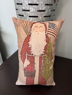 a santa clause pillow sitting on top of a wooden table next to a metal basket