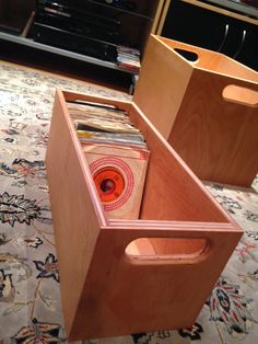 two wooden boxes with records in them on the floor