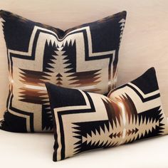 two black and white pillows sitting next to each other