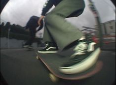 a man riding a skateboard down the side of a street next to another person