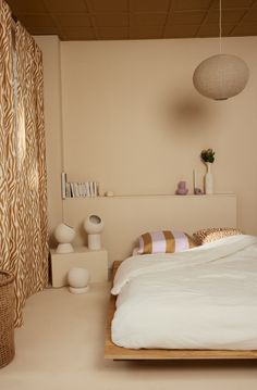 a bed with white sheets and pillows on top of it in a room filled with furniture