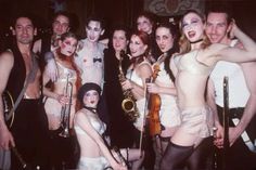 a group of people dressed in costumes posing for a photo with instruments and music equipment