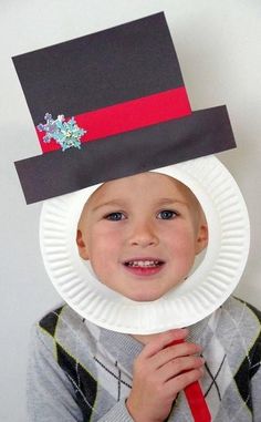 a young boy wearing a paper plate hat