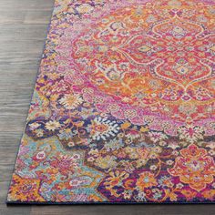 an orange, pink and blue rug on a wooden floor