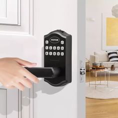 a person's hand is holding an electronic door lock