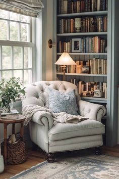 a chair in front of a book shelf filled with lots of books and a lamp