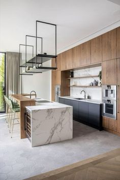 a kitchen with marble counter tops and an island in front of the stove top oven