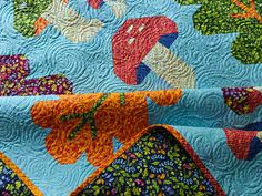 a close up of a colorful quilt on a bed