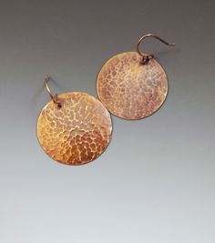 "I make these earrings from hammered copper discs (1 3/8\" round). I patina the copper and then seal the metal to protect the finish. Total drop from the top of the copper ear wire is about 2\". Copper is sealed to protect finish. These are my favorite! I wear thm all the time! Comes gift boxed with metal care instructions." Hammered Copper Drop Earrings, Rust Colored Hammered Copper Jewelry, Brown Hammered Copper Earrings, Electroformed Round Metal Earrings, Round Electroformed Metal Earrings, Hand Forged Brass Earrings In Brown, Handmade Hammered Bronze Copper Jewelry, Hand-forged Copper Earrings In Rust Color, Bronze Round Earrings