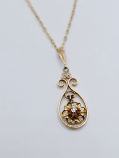 Very nice antique pendant necklace featuring a tiny genuine diamond set in solid 10K yellow gold. The pendant is an openwork filigree teardrop with a filigree flower charm in the center.  The flower has a raised prong set diamond accent.  The pendant is around 1 inch long including the bale.  The bale is stamped 10K. The antique chain is solid 10K gold with a spring ring clasp. It is 16 inches long. This piece is in very nice condition for it's age.  The back of the bale is a bit wavy and there Anniversary Diamond Pendant Necklace With Filigree, Oval Diamond Filigree Necklace, Vintage Gold Diamond Necklace For Formal Occasions, Ornate Yellow Gold Diamond Necklace, Vintage Gold Diamond Necklace, Antique Pendant Diamond Necklace Gift, Vintage Rose Cut Diamond Pendant Necklace, Antique Rose Cut Diamond Necklace Gift, Vintage Diamond Necklace In Yellow Gold