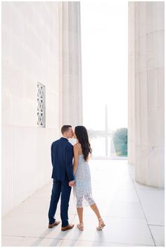 an engaged couple kissing in front of the lincoln memorial