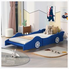 a child's bedroom with a blue car bed and rugs on the floor