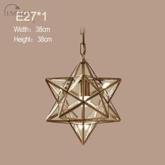 a star shaped light hanging from the ceiling in front of a beige background with white lettering