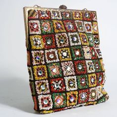 Description: Vintage 1960's beaded and jeweled carpet bag Made up of vibrant jewels and seed beads Gold chain Gold brocade style closure along with gold frame Width: 9" Length: 10" 8" chain Details: Size: OSColor: MulticoloredCondition: Good Shipping: Standard: $9.95Expedited: $19.95 Multicolor Sequined Evening Bag, Multicolor Rectangular Evening Bag For Festivals, Vintage Multicolor Beaded Evening Bag, Multicolor Beaded Rectangular Evening Bag, Multicolor Rectangular Evening Bag For Festive Occasions, Multicolor Rectangular Evening Bag For Celebrations, Bohemian Embellished Rectangular Evening Bag, Antique Multicolor Rectangular Bag, Antique Multicolor Rectangular Bags