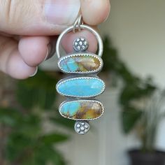 "I'm obsessed with the color in this turquoise  Three Kingman turquoise cabs with blues and browns sit in a drop setting with two handmade silver flowers.  I oxidized her to bring out the details and give her a rustic vintage vibe. Measurements:  42mm x 19mm Comes on a 20\" sterling silver adjustable chain. Turquoise is connected to the healing energy of water, the life-giving element that sustains the planet and the origins of life itself. This energy of renewal and rejuvenation is what gives the turquoise crystal meaning. It has a unique ability to support healing intentions and overall well-being. The water-like qualities of the turquoise stone also guide you to a state of calm and tranquility, which can aid in stress-relief and the elimination of negative energies. In this way, you can Artisan Blue Turquoise Multi-stone Necklace, Artisan Blue Multi-stone Turquoise Necklace, Artisan Multi-stone Turquoise Necklace, Blue Multi-stone Bohemian Turquoise Necklace, Bohemian Blue Multi-stone Turquoise Necklace, Bohemian Turquoise Cabochon Necklace, Earthy Turquoise Chrysocolla Jewelry, Healing Intentions, Turquoise Healing Properties