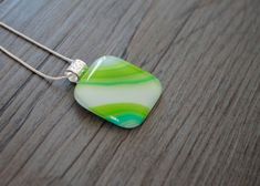 Vibrant bands of green mix with pale blue and a wide white strip in this beautiful square pendant. It measures just under 1 1/4" wide and 1 1/4" long (not including the bail). Properly annealed for strength and durability, this pendant has a smooth, glossy surface with beautiful colours that will not scratch off.This pendant comes ready to wear with your choice of silver plate snake chain or satin necklace (in black or white). The silver bail on this pendant is large enough to accommodate almost Satin Necklace, Glass Fusion, Protection Necklace, Square Pendant, Beautiful Colours, Aura Quartz, Vibrant Green, Labradorite Pendant, Black Tourmaline