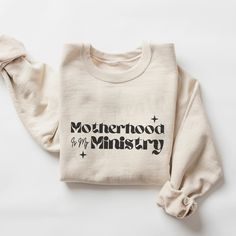 Motherhood Is My Ministry Sweatshirt. Choose the color, size, and quantity of your sweatshirt from the drop-down menu. Our unisex heavy blend crewneck sweatshirt is pure comfort. They are made from polyester and cotton. The collar is ribbed knit, so it retains its shape even after washing. No itchy side seams on these sweaters. -50% cotton, 50% polyester -Medium-heavy fabric -Loose fit -Sewn-in label -Runs true to size but do refer to the size chart shown in the images to make sure you are getti Cotton Sweatshirt With Name Print, Motherhood Is My Ministry, Christian Sweatshirts, Homeschool Shirts, Christian Sweatshirt, Color Calibration, Christian Gifts, Sew-in Labels, Heavy Fabric