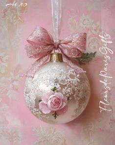 a white ornament with pink flowers and a bow