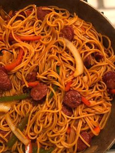 a skillet filled with noodles, meat and vegetables