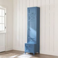 a tall blue cabinet sitting on top of a wooden floor next to a white wall