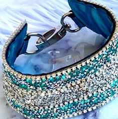 a blue bracelet with lots of crystals on it