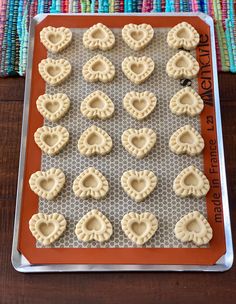 heart shaped cookies on a baking sheet ready to go into the oven for valentine's day