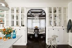 a kitchen with white cabinets and wood floors