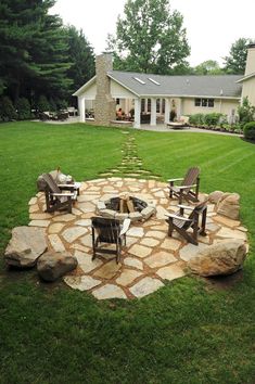 an outdoor fire pit with chairs around it