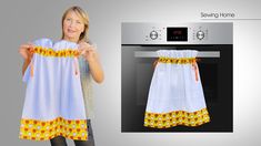 a woman holding up a white and yellow dress with pineapples on it, next to an oven