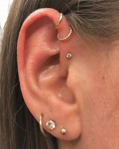 a woman wearing three different ear piercings on her left ear and the other one is in