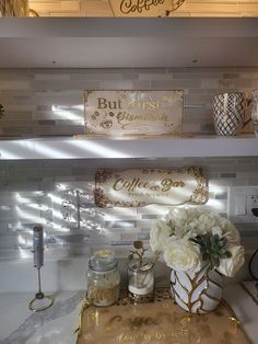 two shelves with flowers and candles on them in a room that has white tile walls