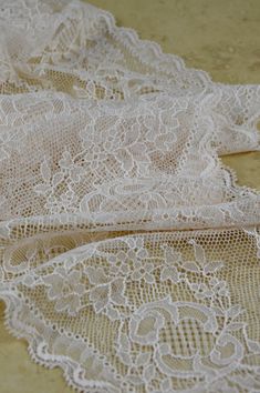 two pieces of white lace sitting on top of a table