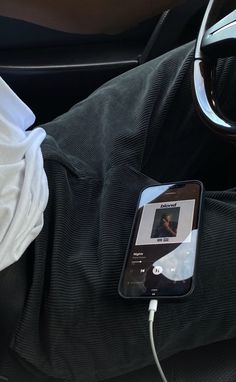 a cell phone is plugged into an mp3 player in the passenger seat of a car