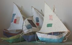 three small sailboats are sitting on a table