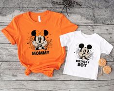 two t - shirts with mickey and minnie mouse on them, one is orange and the other is white