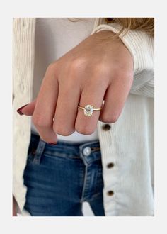 a woman's hand wearing a gold ring with a small diamond on the middle