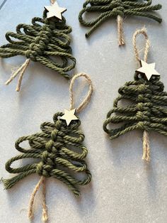 four christmas tree ornaments made out of rope and twine with white stars on them