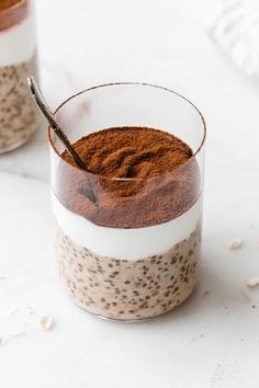 two glasses filled with chia pudding and topped with chocolate powder, cinnamon sprinkles