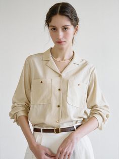 Classic mood shirts that made of lightweight and cool rayon blended fabric. Featuring the open-collar design, out-pockets that gives casual mood, and the golden buttons detail that elevated the quality. The loose and comfortable silhouette goes well with various bottoms like skirts, trousers, and denim jeans. - Minimal open-collar design- Out-pockets with golden button at chest- Golden buttons closure at front, pockets, and cuffs- One-button barrel cuffs- Loose and comfortable silhouette- Soft, lightweight, and breezy fabric made Luxury Shirt With Buttoned Pockets For Fall, Luxury Collared Tops With Buttons, Luxury Collared Blouse With Button Closure, Luxury Relaxed Fit Tops With Lapel Collar, Fall Shirt With Buttoned Pockets, Affordable Relaxed Fit Blouse With Button Cuffs, Luxury Cream Button-up Shirt, Luxury Cream Shirt With Relaxed Fit, Luxury Short Sleeve Shirt With Camp Collar For Spring