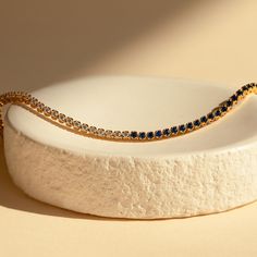 Make a shimmering statement with our Blue Diamond Tennis Bracelet. Elegant and dainty, it adds the perfect bold, finishing touch to your outfit for special occasions like anniversaries or weddings. A minimalist accessory sure to shine and a dazzling symbol of “something blue” for brides. Finish/Material: 18K Gold Over Brass ∙ Rhodium Over Brass Clasp: Box clasp and side prong closure Featuring a ~3mm Tennis Bracelet with half CZ Sapphire and half CZ Diamond stones Model showcases a romantic, min Elegant Adjustable Blue Gold Bracelet, Elegant Blue Adjustable Gold Bracelet, Minimalist Blue Jubilee Bracelet, Blue Minimalist Jubilee Bracelet, Elegant Blue Bracelets With Sparkling Stones, Elegant Blue Gold-plated Bracelets, Elegant Blue Gold Bracelet For Formal Occasions, Elegant Blue Bangle Gold Bracelet, Elegant Blue Bracelets For Anniversary