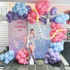 a woman standing in front of a balloon arch with balloons around her and the words my birthday eva on it