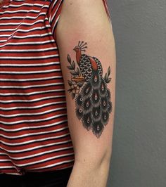 a woman's arm with a peacock tattoo on the left side of her body