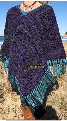 a woman wearing a purple and blue crocheted shawl with fringes on it