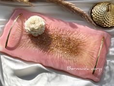 a pink tray with a white flower on it