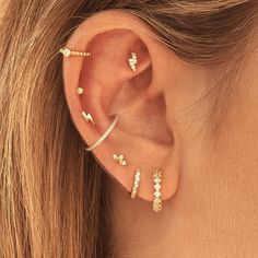 a woman's ear with three different types of piercings on the side of her ear