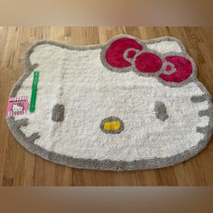 a hello kitty rug on the floor with a pen and pencil in it's mouth