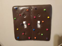 two light switch plates with chocolate frosting and multi colored sprinkles