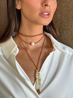 The Joie DiGiovanni Leather, Pearl, and Nugget Lariat features beautiful pearls and gold plated nuggets throughout a beautiful natural leather. Loop this once, twice or however you want - the possibilities are endless! 10-11mm AA quality freshwater pearls Single AA quality 12-14mm freshwater pearl at center gold plated nuggets 2MM natural leather Luxury Pearl Lariat Necklace, Elegant Brown Lariat Jewelry, Elegant Brown Lariat Necklace, Elegant Leather Lariat Jewelry, Luxury Lariat Necklace With Pearl Pendant, Luxury Pearl Pendant Lariat Necklace, Elegant Gold Beaded Lariat Necklace, Pearls Jewelry, Freshwater Pearl Jewelry